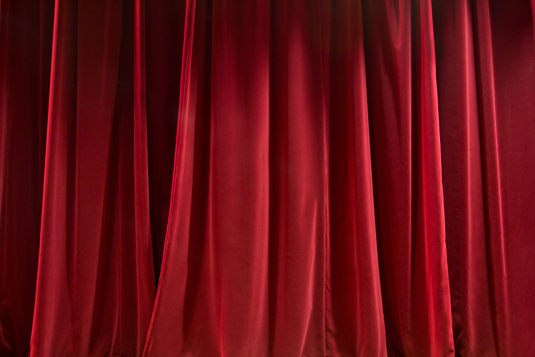 Silk red curtains hanging under light